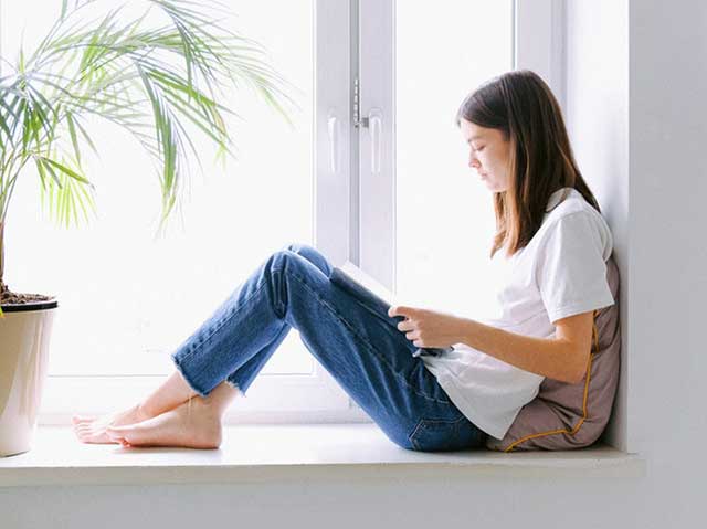 Girl studying beside window